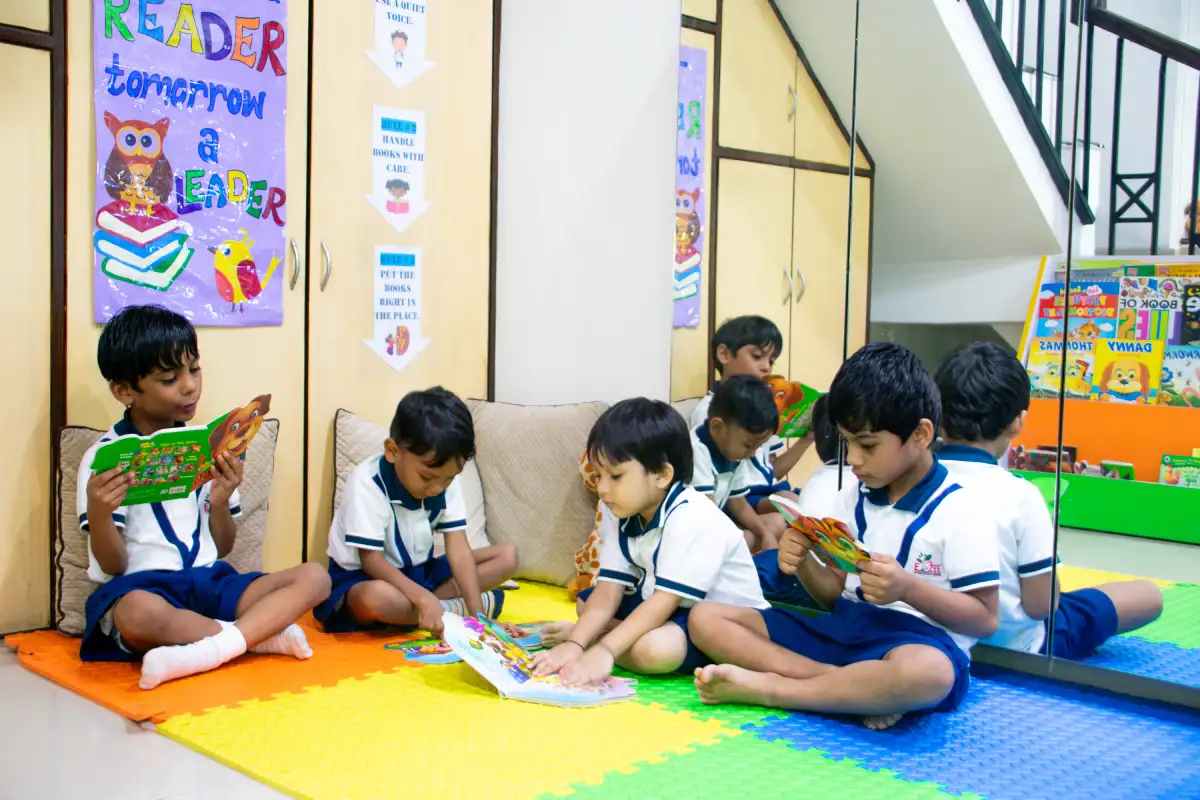 Children and teacher sitting together in a safe preschool classroom that supports emotional security social development and early learning at Elzee Preschool