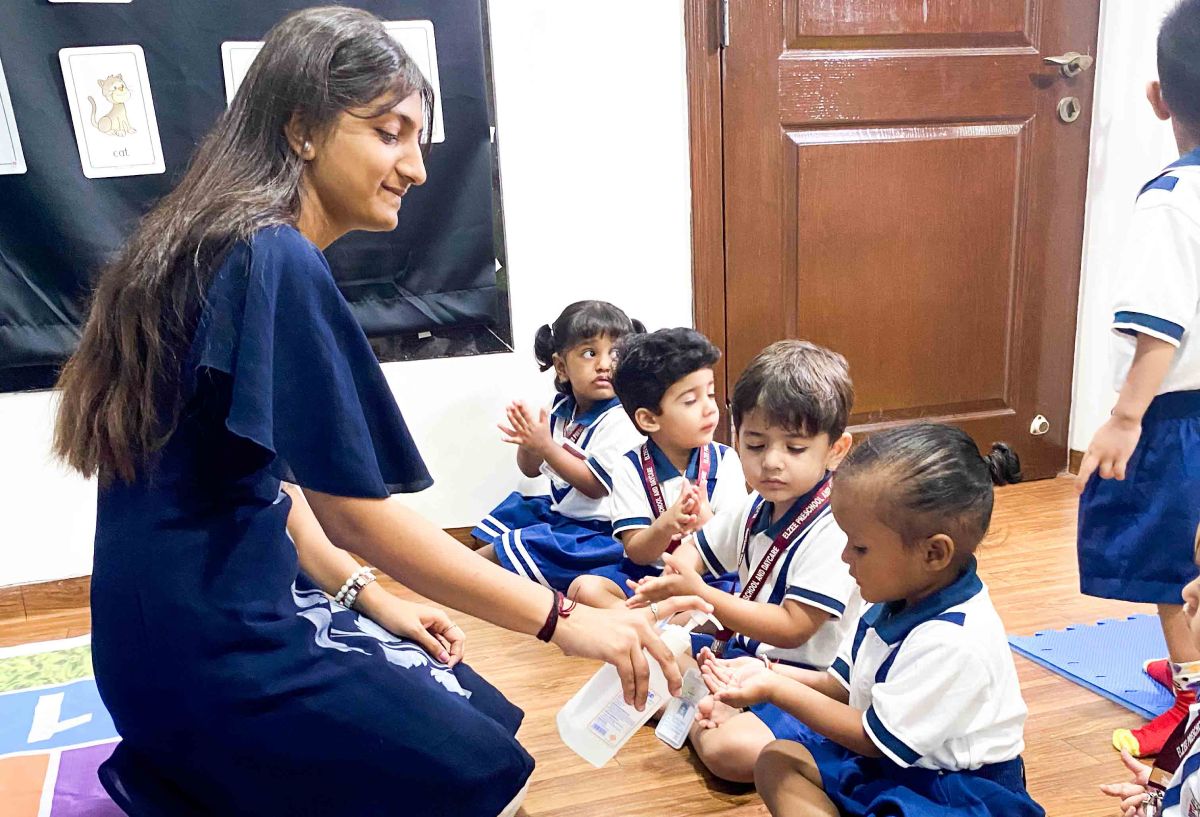Teacher interacting with preschool children during a classroom learning activity in a kindergarten environment